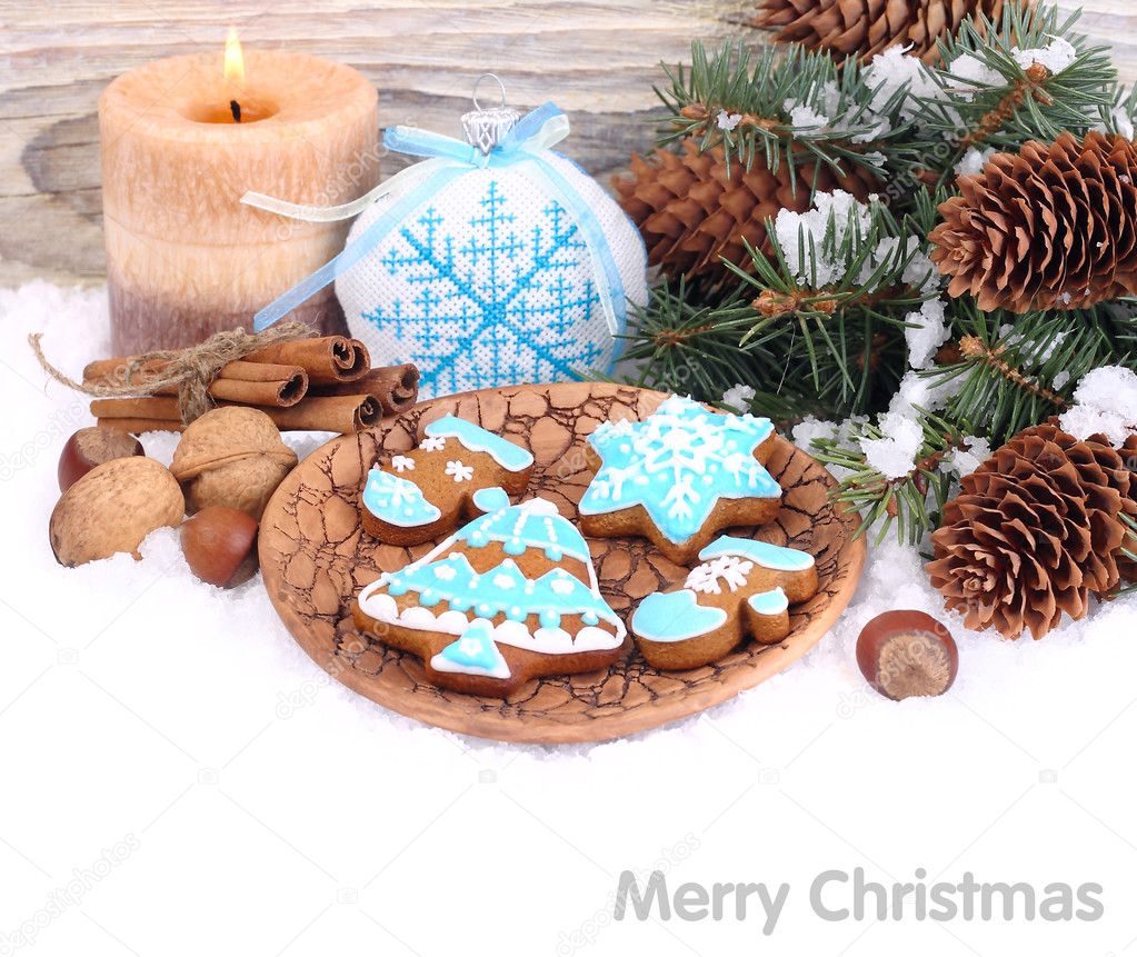 Christmas ginger cookies in blue glaze, nuts and cones on snow on a white background. A Christmas background with a place for the text.