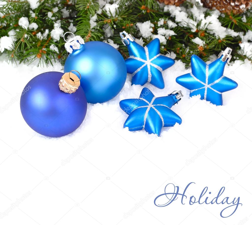 Blue Christmas balls and stars and branches of a Christmas tree on a white background. A Christmas background with a place for the text.