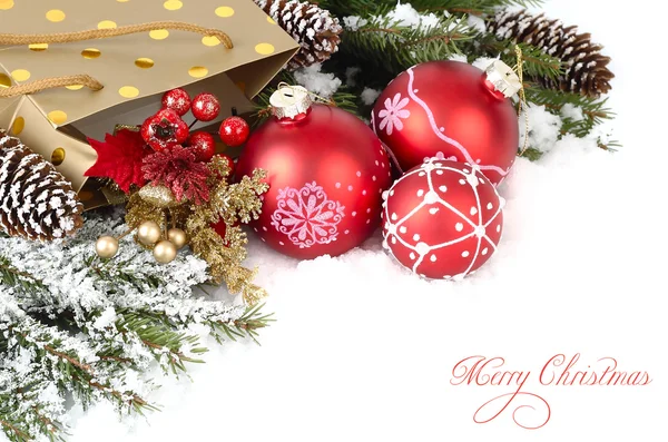 Bolas rojas de Navidad, ramas cubiertas de nieve de un árbol de Navidad y el cono en la nieve sobre un fondo blanco. Un fondo navideño con un lugar para el texto . —  Fotos de Stock