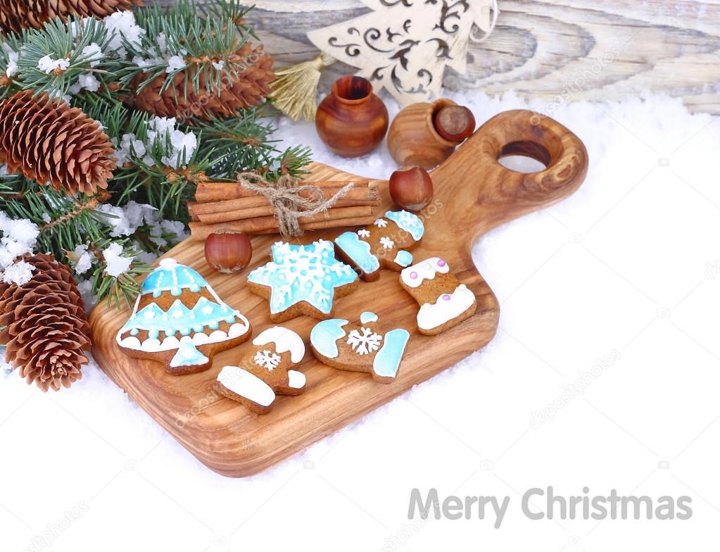 Christmas ginger cookies in blue glaze, nuts and cones on snow on a white background. A Christmas background with a place for the text.