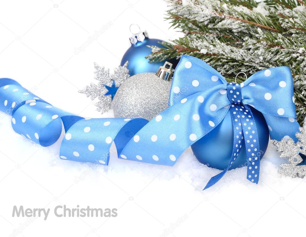 Christmas ball with a blue bow on snow on a white background. A Christmas background with a place for the text.