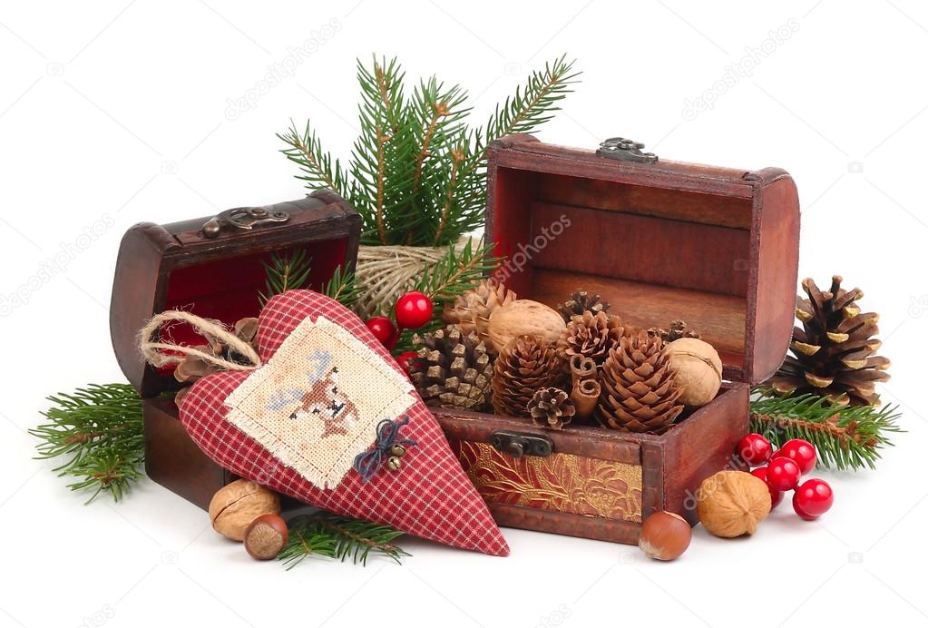 Textile checkered heart with the embroidered deer, cones and nuts on branches of a Christmas tree on snow on a white background.