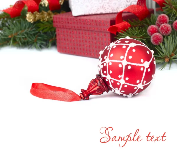 Bola de Natal vermelho e caixas de presente de Natal em um fundo branco. Um fundo de Natal com um lugar para o texto . — Fotografia de Stock