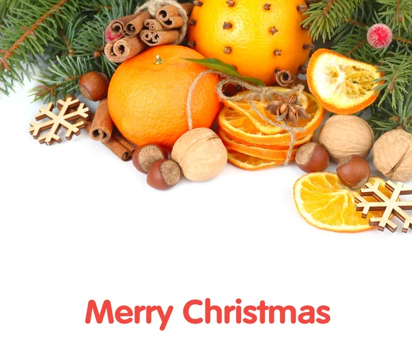 Dried oranges, nuts and cinnamon on branches of a Christmas tree on a white background. A Christmas background with a place for the text. — Stok fotoğraf