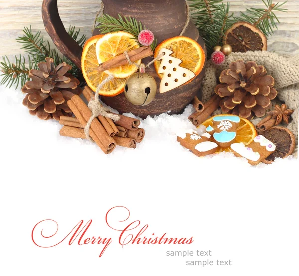 Christmas ginger cookies, cones, nuts and dried oranges and a clay jug on snow on a wooden background. A Christmas background with a place for the text. — 图库照片