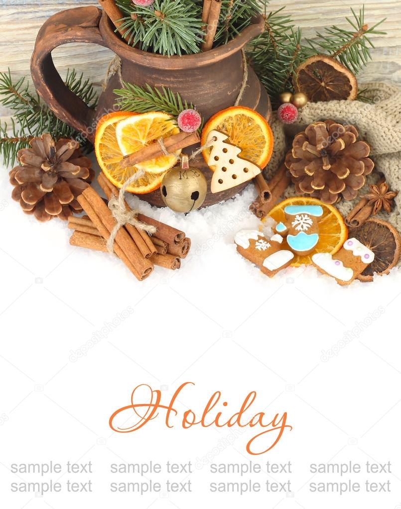 Christmas ginger cookies, cones, nuts and dried oranges and a clay jug on snow on a wooden background. A Christmas background with a place for the text.