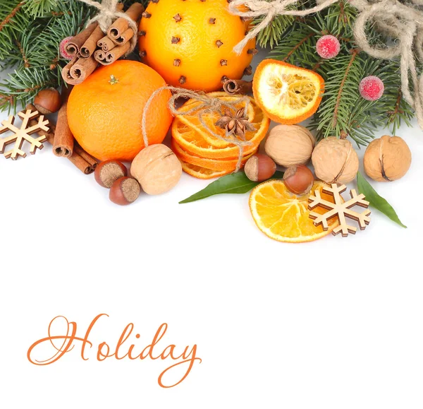 Kerstmis samenstelling met gedroogde sinaasappelen, kaneel en noten op takken van een kerstboom op een witte achtergrond. Een achtergrond van Kerstmis met een plek voor de tekst. — Stockfoto