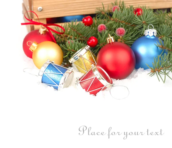 Vánoční koule a dekorativní bicí na sněhu na bílém pozadí. Vánoční pozadí s místem pro text. — Stock fotografie