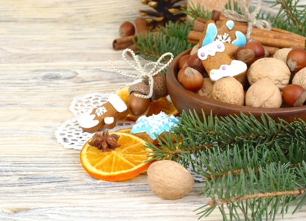 Composición navideña con naranjas secas, canela, nueces y galletas de jengibre sobre un fondo de madera. Un fondo navideño con un lugar para el texto . —  Fotos de Stock
