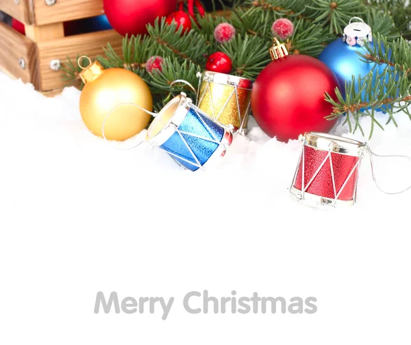 Multi-gekleurde kerstballen en decoratieve drums op sneeuw op een witte achtergrond. Een achtergrond van Kerstmis met een plek voor de tekst. — Stockfoto