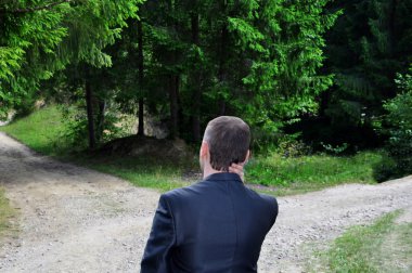 businessman with a choice near the forked road clipart