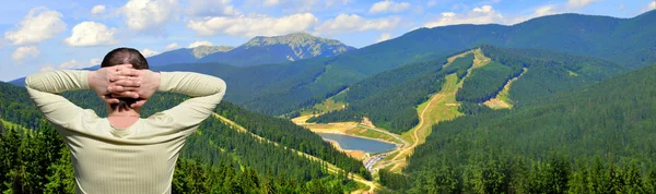 Man op een bergtop die kijken naar de prachtige bergen — Stockfoto