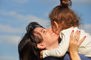 Mutlu anne kızı gökyüzüne karşı sarılma