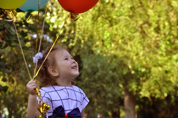Щаслива дитина з повітряними кулями в парку — стокове фото