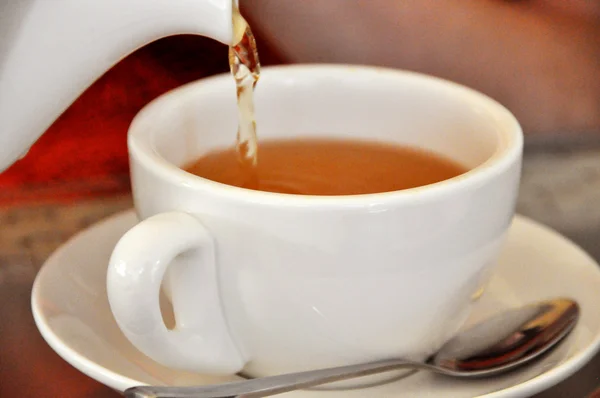 Tea being poured into tea cup 