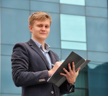 Arka plan cam üstündeki bir klasörle işadamı