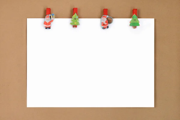 クラフト紙の背景にサンタの服ピンやクリスマスツリーと紙の空白の白いシート クリスマス 冬の休日の招待モックアップ — ストック写真