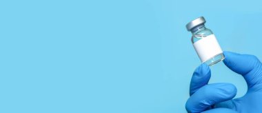 Doktor ya da hemşire ellerinde aşı tutan eldivenler var. 