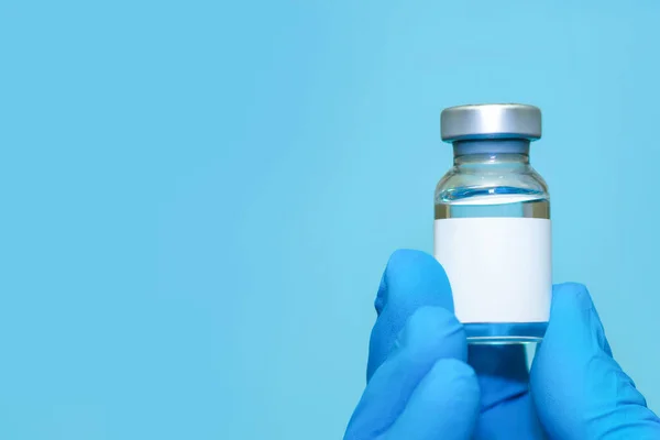 Doktor ya da hemşire ellerinde aşı tutan eldivenler var. 