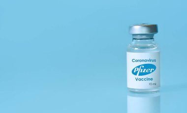 Harkiv. Ukrayna. 9 Ocak 2021. Covid-19 aşısı Pfizer ve BioNTech 'in işbirliğiyle mavi bir arka plan üzerinde geliştirildi. Mesaj için kopyalama alanı.