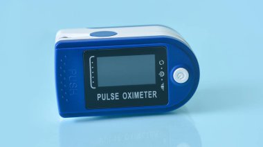 Taşınabilir nabız oksimetresi mavi arkaplanda izole edildi.