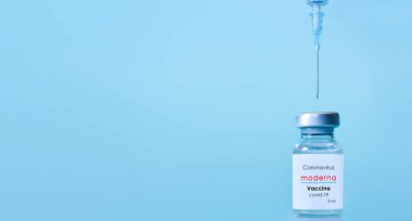 Harkiv. Ukrayna. 9 Ocak 2021. Şırınga, Coronavirus aşısı şişesi. Moderna logosu mavi bir arka plan. Tıp, sağlık ve bilim konsepti. Pankart