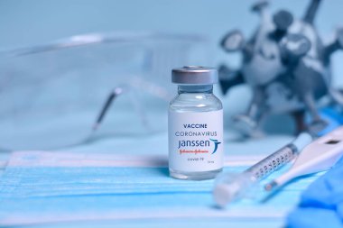 Harkiv. Ukrayna. 1 Şubat 2021. İçinde Janssen Johnson ve Johnson logosu, şırınga, maske, termometre, eldiven, gözlük ve 3D virüs modeli olan Coronavirus aşısı şişesi. Tıp konsepti, sağlık hizmeti