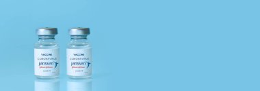 Harkiv. Ukrayna. 9 Ocak 2021. Janssen Johnson ve Johnson 'la birlikte iki şişe Coronavirus aşısı. Mavi bir arka plan logosu. Tıp, sağlık ve bilim konsepti..