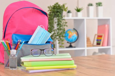 Okul gereçleri, dezenfektan ve tıbbi koruyucu maskelerle dolu sırt çantası. Coronavirüs 'ten sonra okula ve anaokuluna. Okul sezonunun başlangıcı..