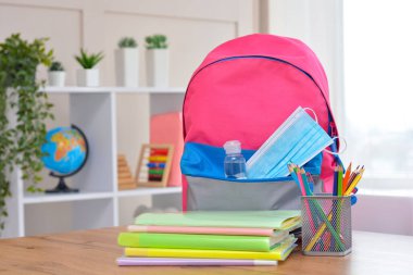 Okul gereçleri, dezenfektan ve tıbbi koruyucu maskelerle dolu sırt çantası. Coronavirüs 'ten sonra okula ve anaokuluna. Okul sezonunun başlangıcı..