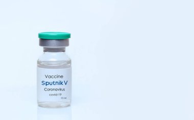 Harkiv. Ukrayna. 9 Ocak 2021. Beyaz bir zemin üzerinde Sputnik V logosu bulunan koronavirüs aşısı şişesi. Tıp, sağlık ve bilim konsepti. Metin için alan kopyala.