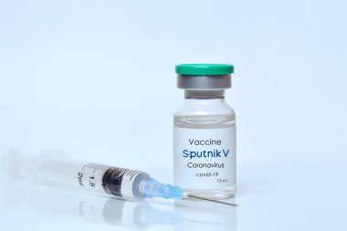 Harkiv. Ukrayna. 9 Ocak 2021. Şırınga, Coronavirus aşı şişesi. Sputnik V logosu beyaz bir zemin. Tıp, sağlık ve bilim konsepti.