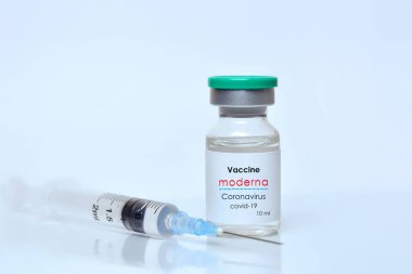 Harkiv. Ukrayna. 9 Ocak 2021. Şırınga, Coronavirus aşısı şişesi. Moderna logosu beyaz bir arka plan. Tıp, sağlık ve bilim konsepti..