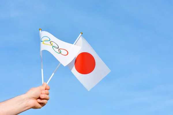 2021年5月23日 乌克兰哈尔科夫 手里拿着日本和奥运会的旗帜在蓝天上飘扬 2020年夏季奥林匹克运动会构想 2021年 日本东京 顶层空间 — 图库照片