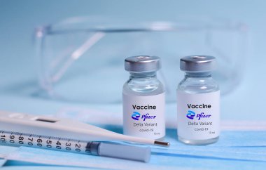 Pfizer ve BioNTech, aşı, şırınga, yüz maskesi, vücut termometresi ve koruyucu gözlükler tarafından geliştirilen Delta Virüsü 'ne karşı aşı içeren ilaç şişeleri..