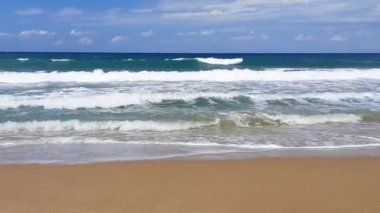 Kumsal, deniz, dalgalar, gökyüzü. Yaz gününde güzel bir deniz manzarası. Plaj alanı. HD video.