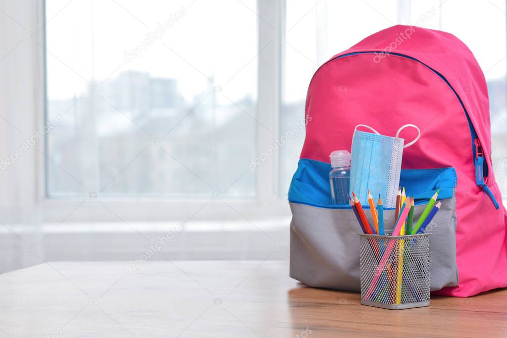 Backpack with school supplies and sanitizer and medical protective mask.Back to school and kindergarten .The beginning of the school season.Virus and disease prevention for kids.Safe Learning.