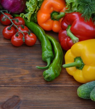 Ahşap arka planda bir sebze seti: havuç, patates, kabak, kırmızı biber, salatalık, sarımsak, domates, marul. Üst görünüm. Boşluğu kopyala