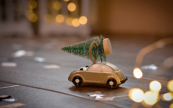 Retro Spielzeugauto Mit Winzigem Weihnachtsbaum Auf Dem Hintergrund Des Weihnachtsbokeh — Stockfoto