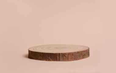 Bej bir arka planda testere kesiği şeklinde yuvarlak tahta bir ağaç. Ürün sunumun için boş sahne gösterisi. Metin için opi alanı.