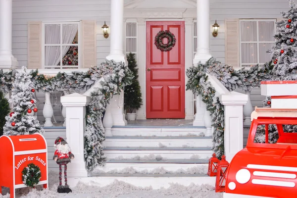 Christmas courtyard with Christmas porch, veranda, wreath, Christmas tree, red car, gnome, letterbox for Santa Claus, lanterns, garland. Merry Christmas and Happy New Year