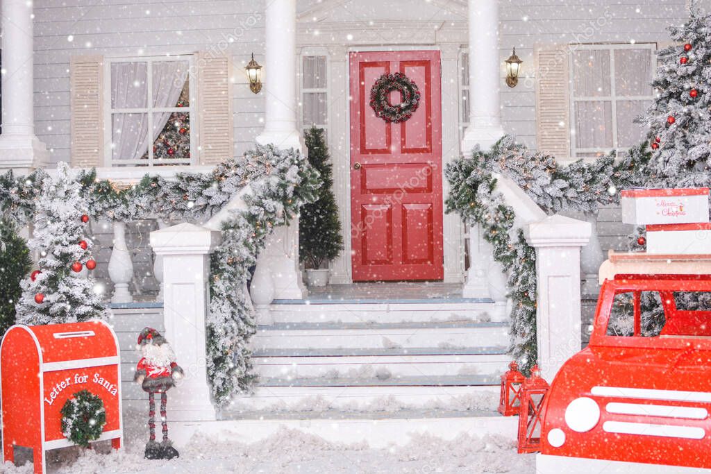 Snowy courtyard with Christmas porch, veranda, wreath, Christmas tree, red car, gnome, letterbox for Santa Claus, lanterns, garland. Merry Christmas and Happy New Year