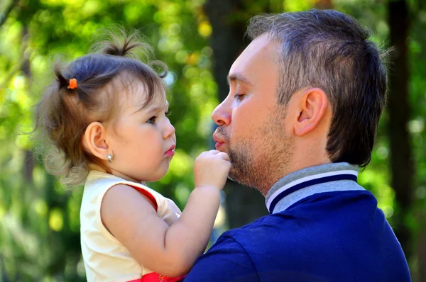 De kleine dochter van zijn vader in zijn armen — Stockfoto