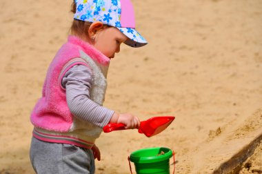 Kum havuzunda oynayan küçük çocuk