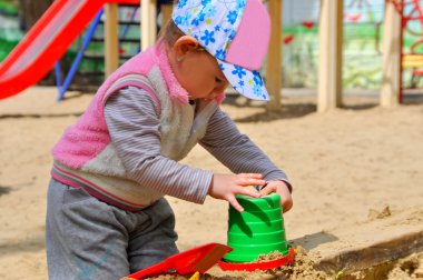 Kum havuzunda oynayan küçük çocuk