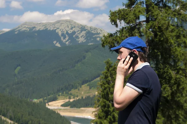 Turist i bergen talar på mobiltelefon — Stockfoto