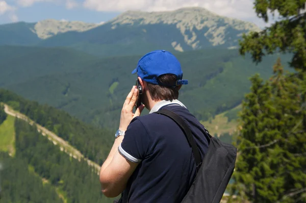Turist i bergen talar på mobiltelefon — Stockfoto
