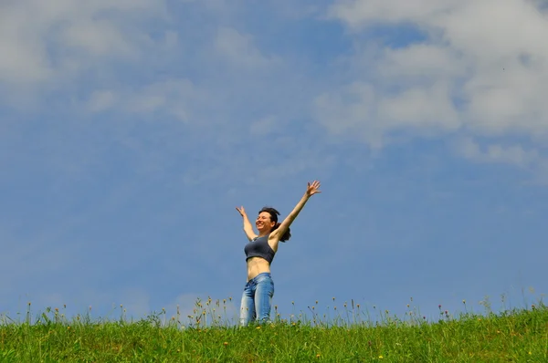 Gelukkig meisje met zijn handen omhoog in tegen de hemel — Stockfoto