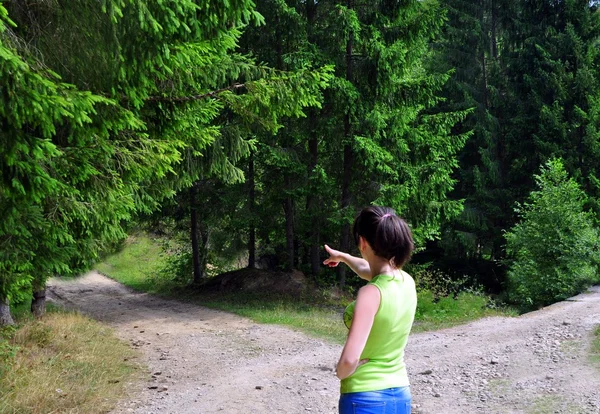 Chica con una opción cerca de la carretera bifurcada —  Fotos de Stock