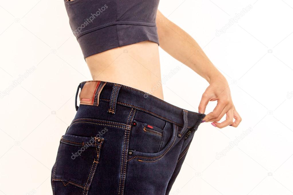  woman in old jeans pant after losing weight. 